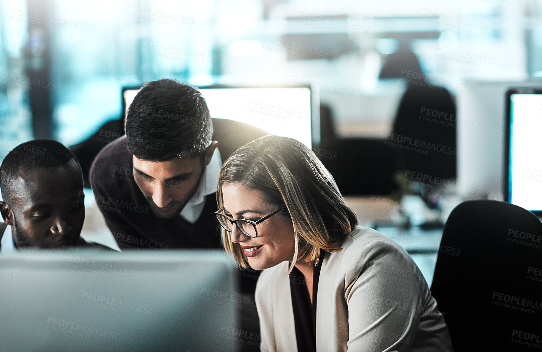 Buy stock photo Shot of three businesspeople working together on a desktop