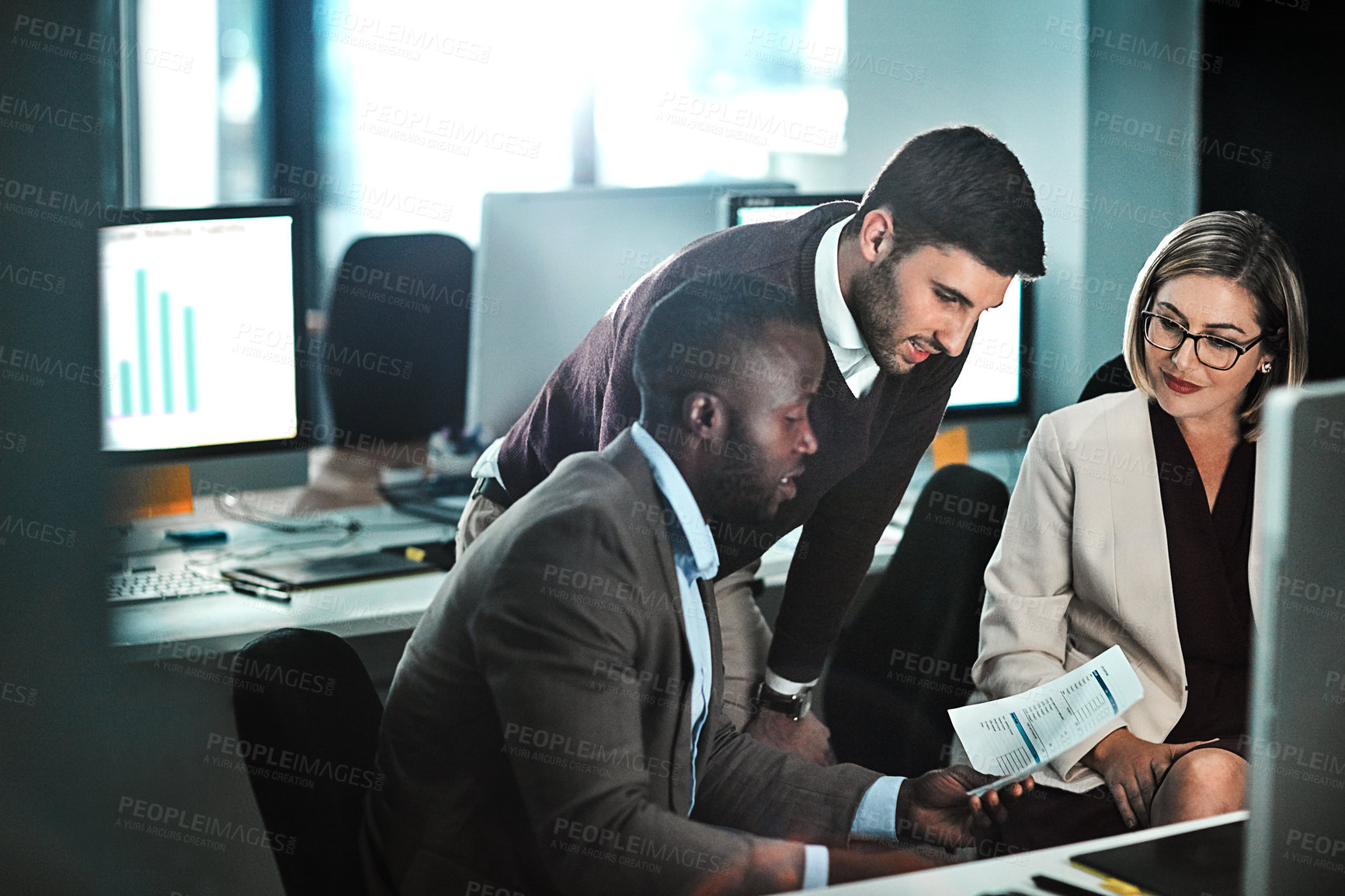 Buy stock photo Shot of three businesspeople working together on a project in an open space