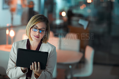Buy stock photo Shot of a businesswoman using a digital tablet during a late night at work
