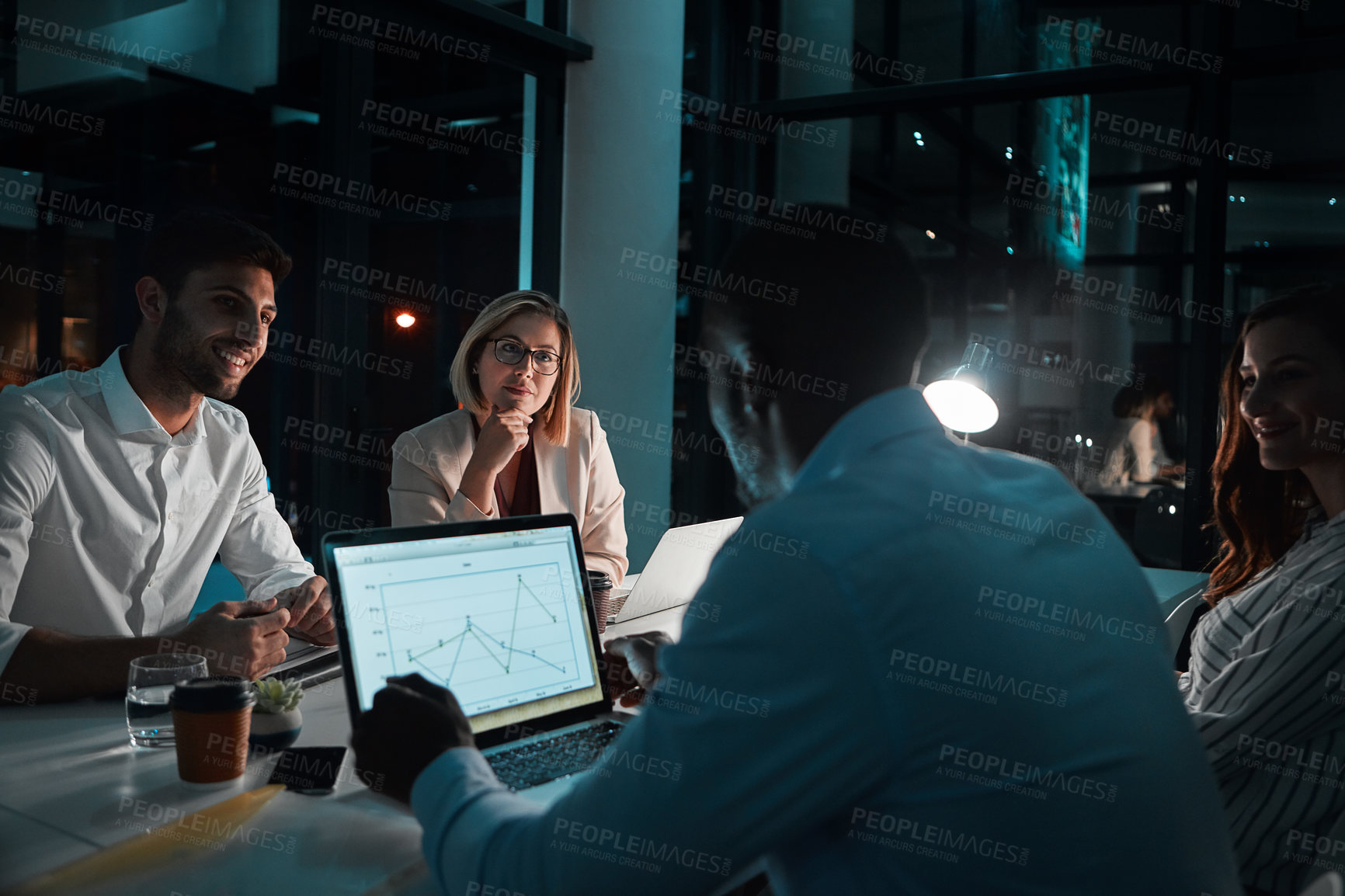 Buy stock photo Shot of colleagues having a meeting during a late night in a modern office