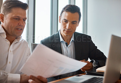 Buy stock photo Shot of two mature businessmen discussing paperwork in a corporate office