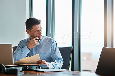 Buy stock photo Shot of a mature businessman working at his desk