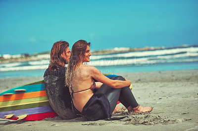 Buy stock photo Shot of a young couple surfing at the beach