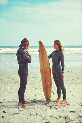Buy stock photo Shot of a young couple surfing at the beach