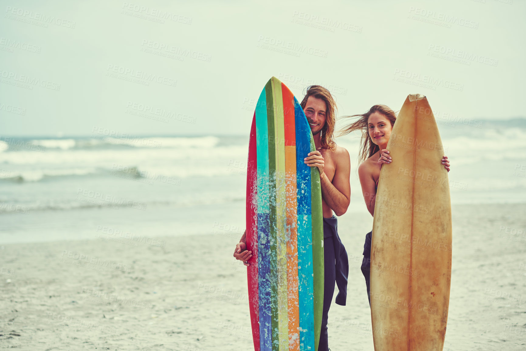 Buy stock photo Shot of a young couple spending the day out surfing