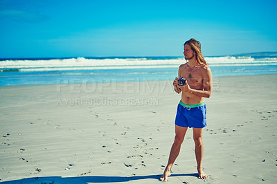 Buy stock photo Shot of a young man spending the day at the beach