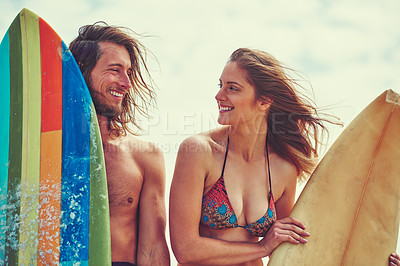 Buy stock photo Shot of a young couple spending the day out surfing