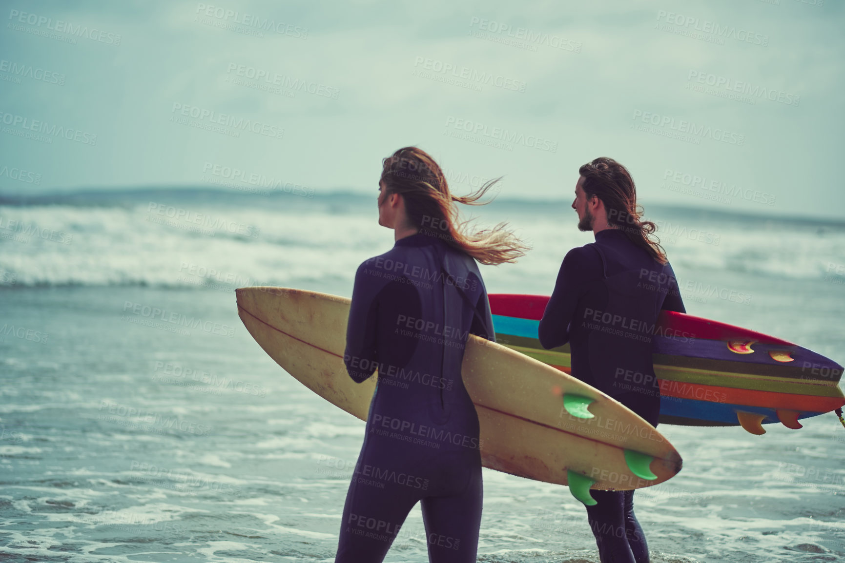 Buy stock photo Shot of a young couple surfing at the beach