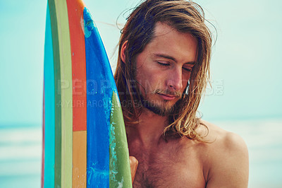 Buy stock photo Cropped shot of a young surfer leaning against his surfboard