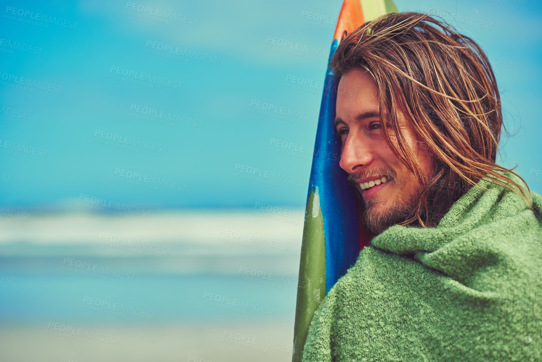 Buy stock photo Cropped shot of a young surfer leaning against his surfboard