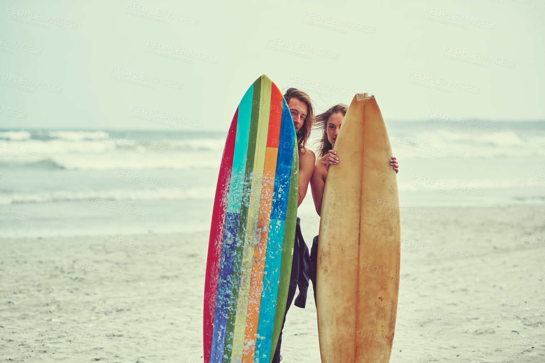 Buy stock photo Shot of a young couple spending the day out surfing