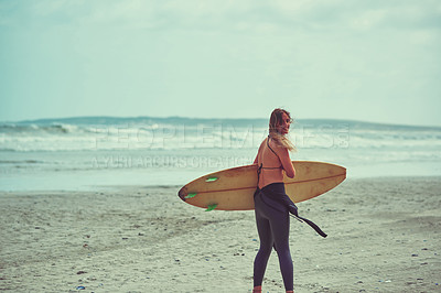 Buy stock photo Shot of a beautiful young woman going for a surf at the beach