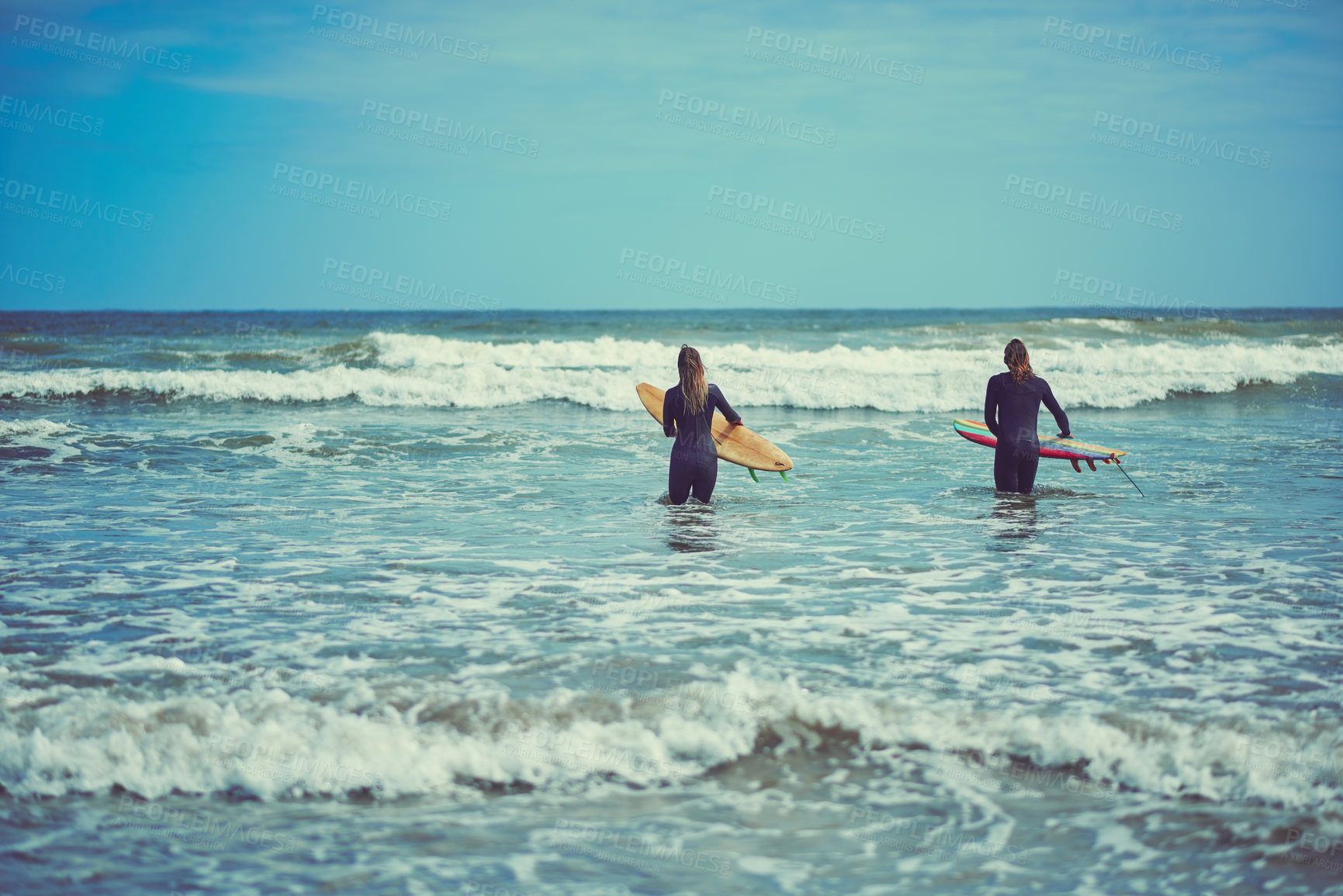 Buy stock photo Shot of a young couple surfing at the beach