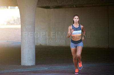 Buy stock photo Full length shot of an attractive young woman taking a run through the city