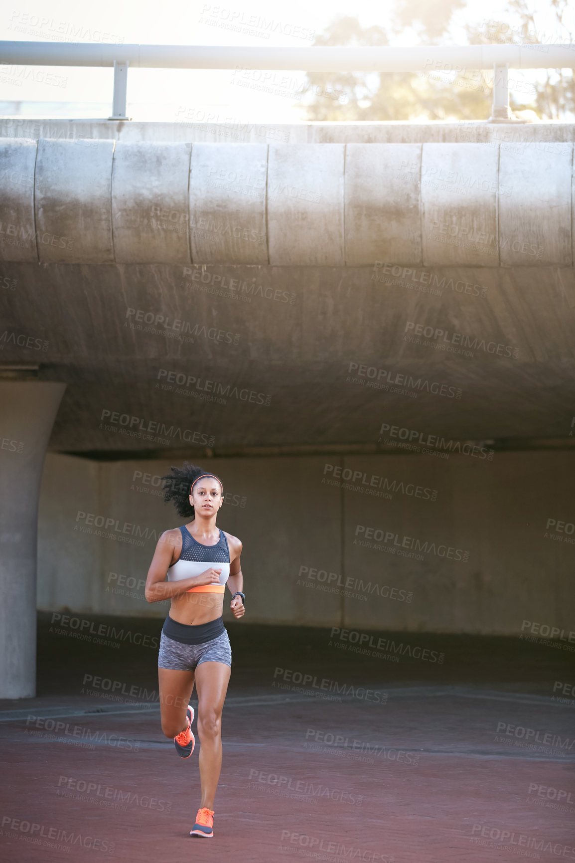 Buy stock photo Full length shot of an attractive young woman taking a run through the city