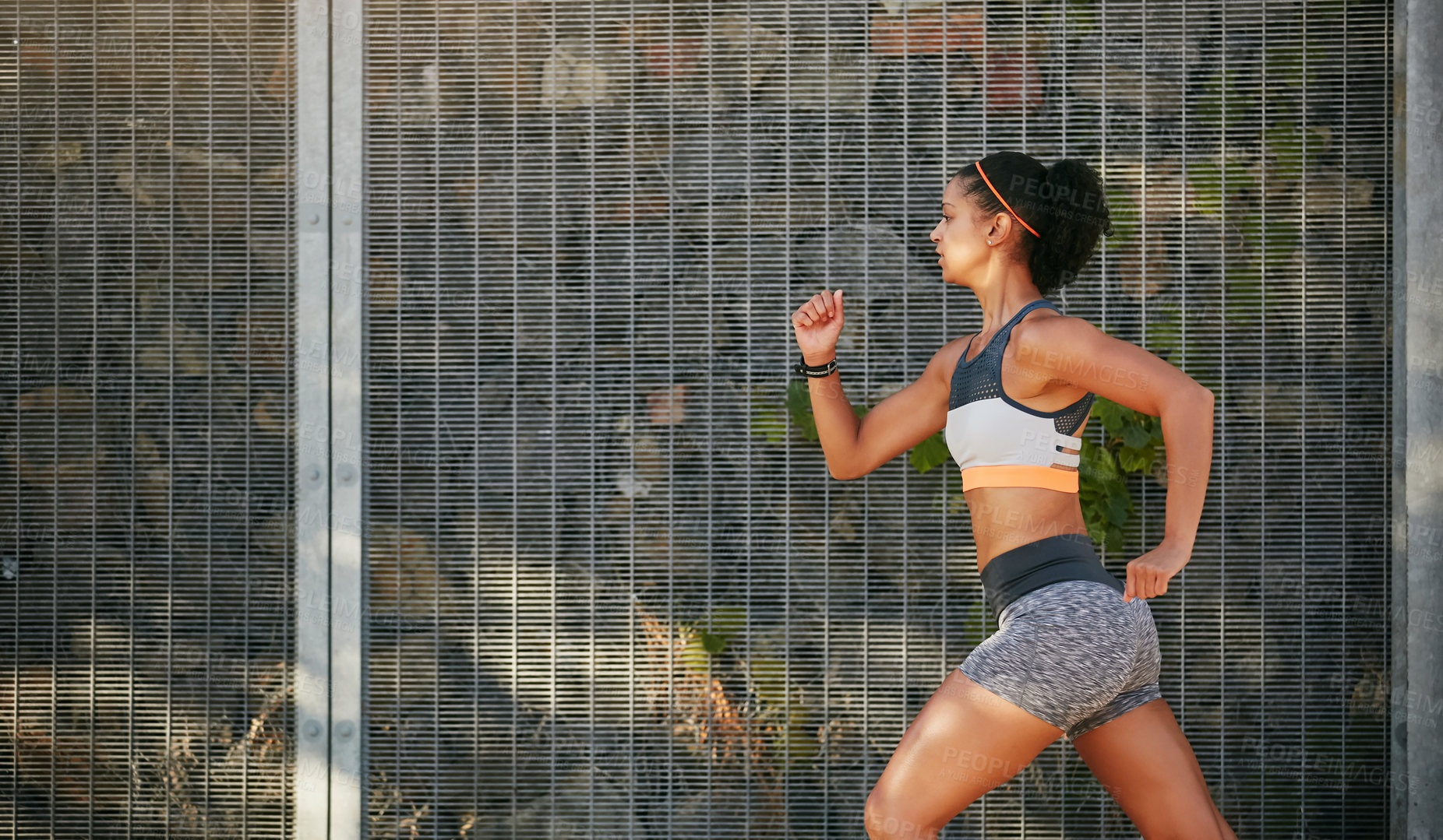 Buy stock photo Cropped shot of an attractive young woman taking a run through the city