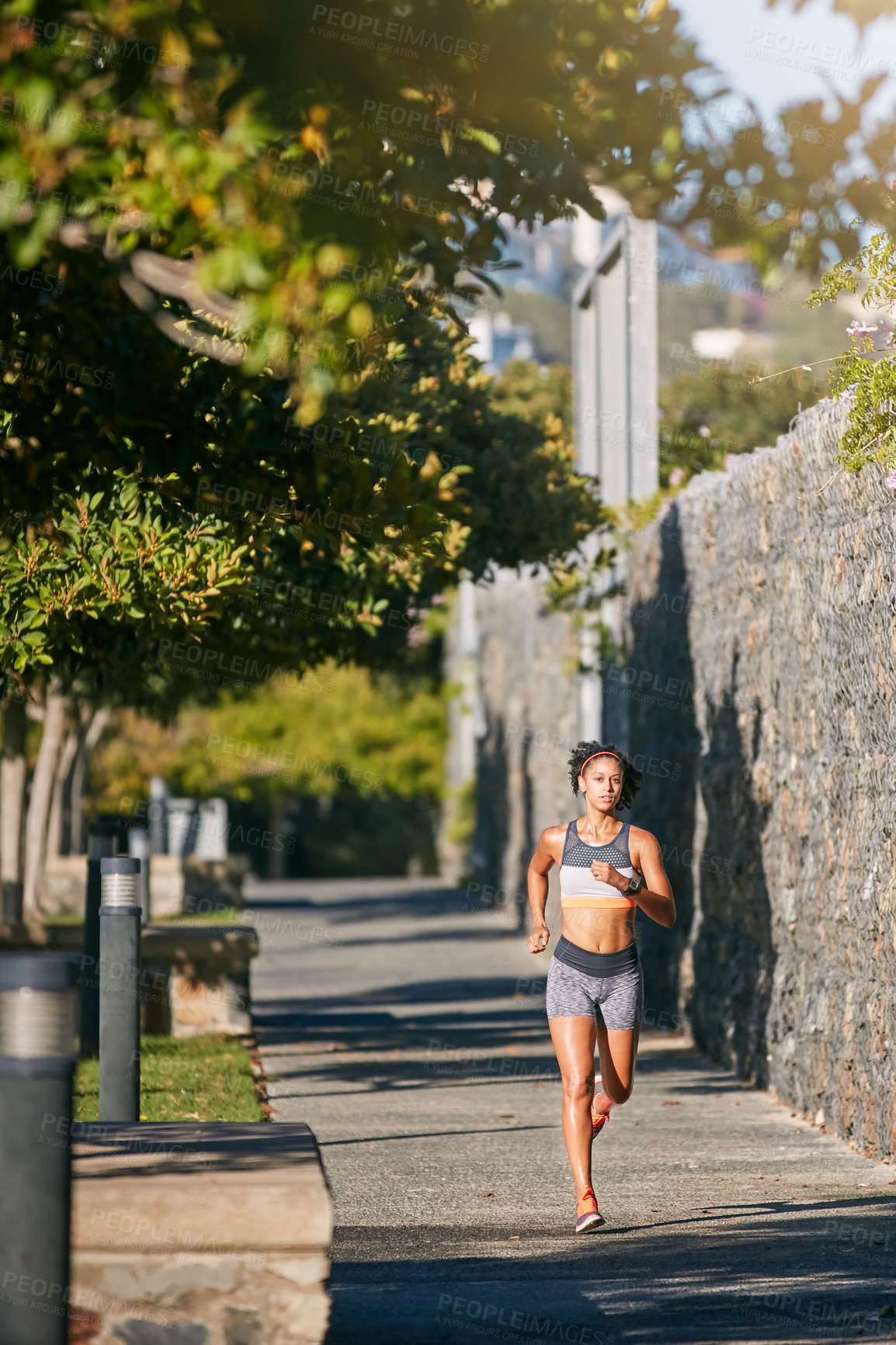 Buy stock photo Full length shot of an attractive young woman taking a run through the city