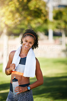 Buy stock photo Portrait of a sporty young woman taking a break while exercising outside