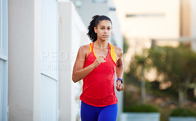 Buy stock photo Shot of a sporty young woman out running in the city by herself