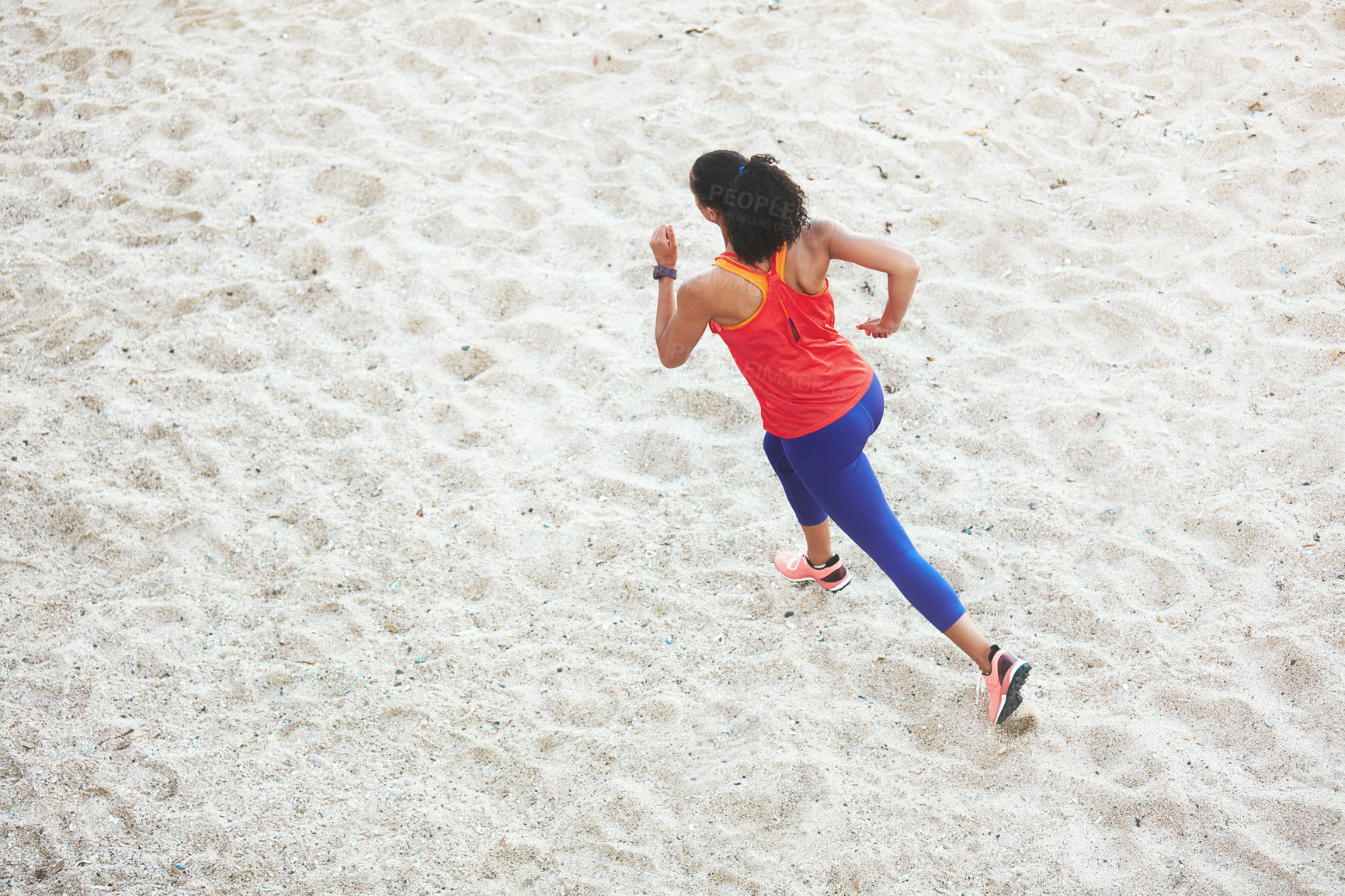 Buy stock photo Shot of a sporty young woman out at the beach for her morning run