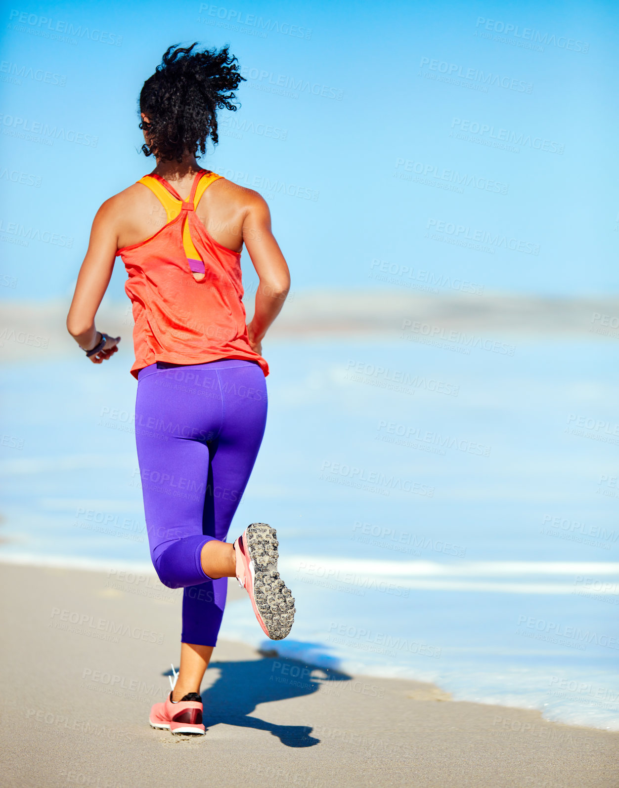 Buy stock photo Shot of a sporty young woman out at the beach for her morning run