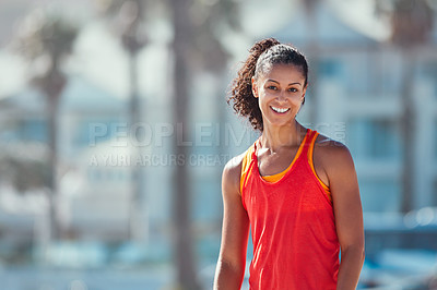 Buy stock photo Shot of a sporty young woman standing outside after her morning workout