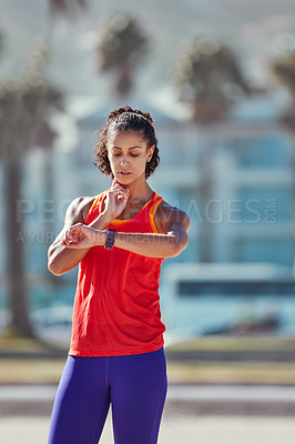 Buy stock photo Shot of a sporty young woman measuring her pulse