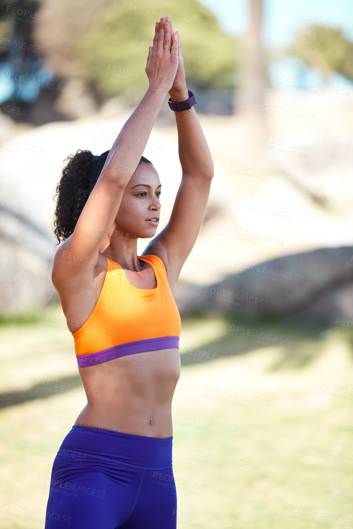 Buy stock photo Shot of an attractive young woman practising yoga at a park