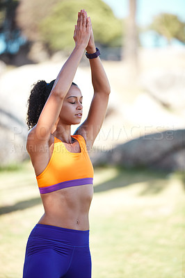 Buy stock photo Shot of an attractive young woman practising yoga at a park