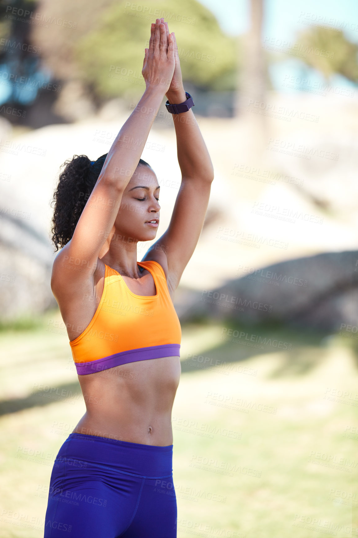 Buy stock photo Shot of an attractive young woman practising yoga at a park