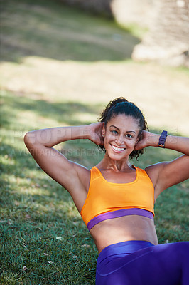 Buy stock photo Shot of a sporty young woman doing sit ups as part of her exercise routine