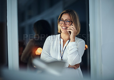 Buy stock photo Shot of a businesswoman talking on a mobile phone during a late night at work