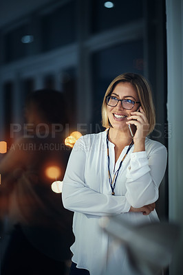 Buy stock photo Shot of a businesswoman talking on a mobile phone during a late night at work