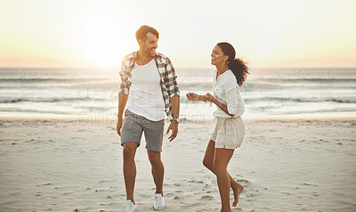 Buy stock photo Shot of a loving couple taking a walk on the beach