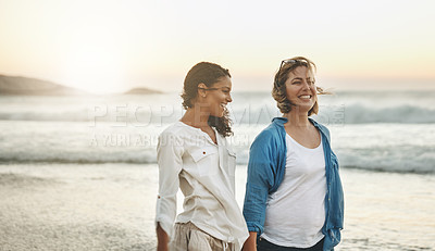 Buy stock photo Shot of a loving couple walking hand in hand on the beach