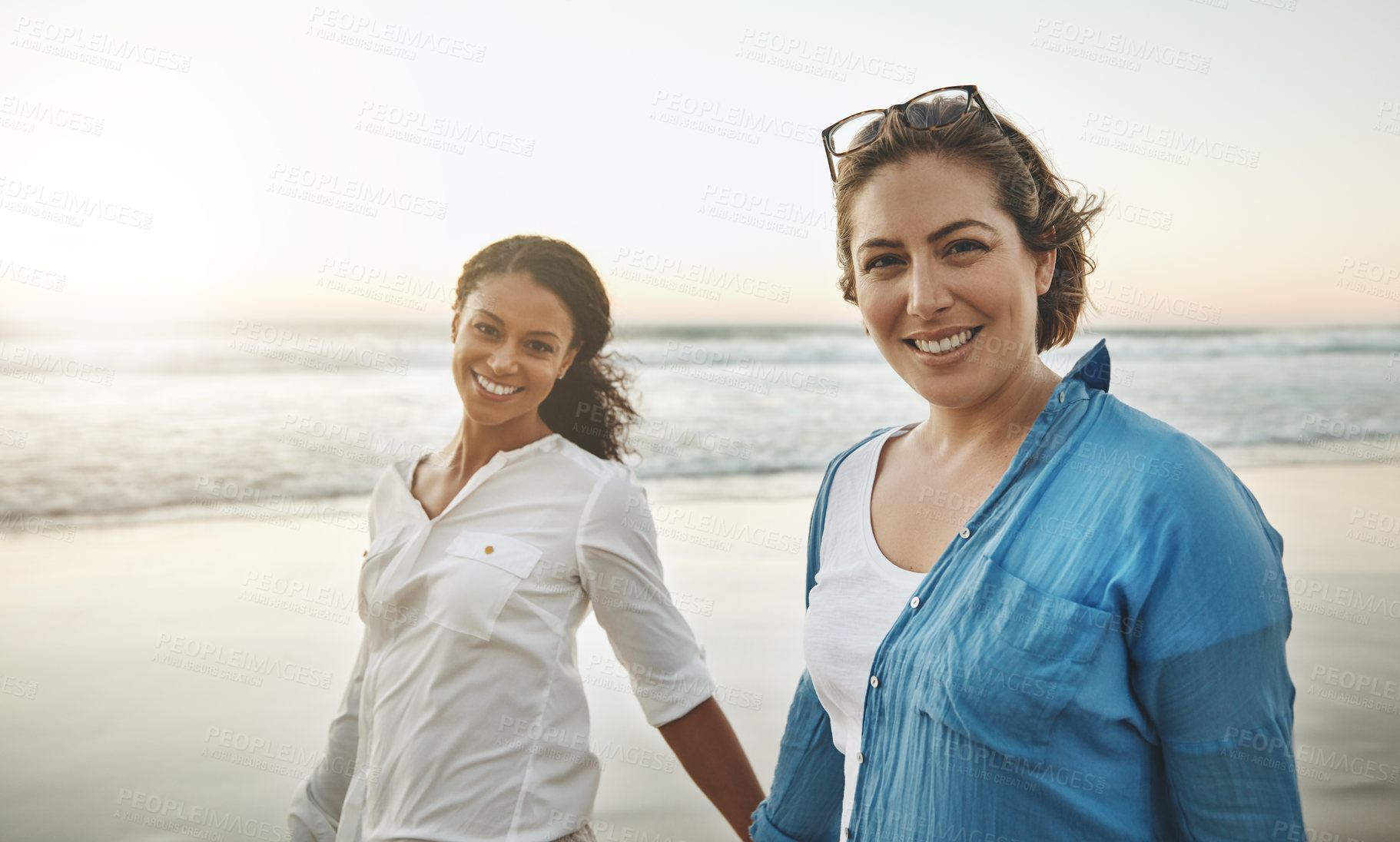 Buy stock photo Shot of a loving couple walking hand in hand on the beach