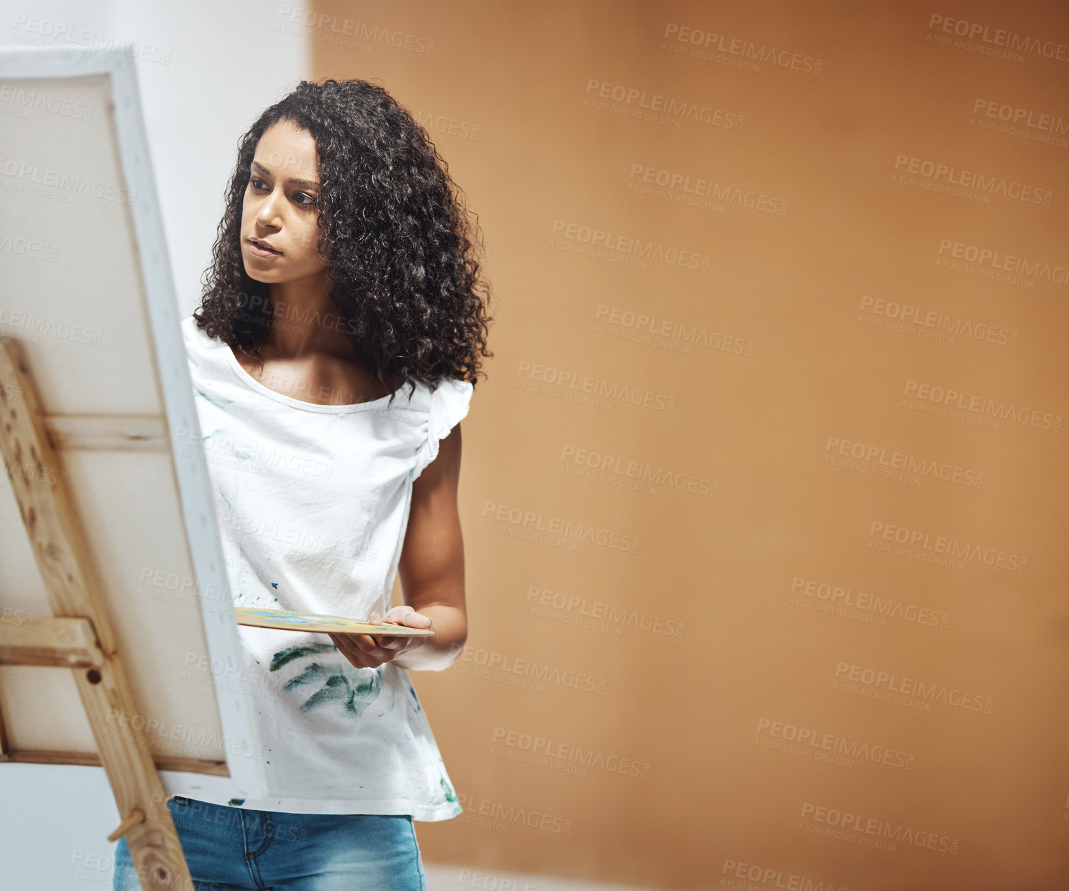 Buy stock photo Shot of an attractive young woman painting on a canvas at home