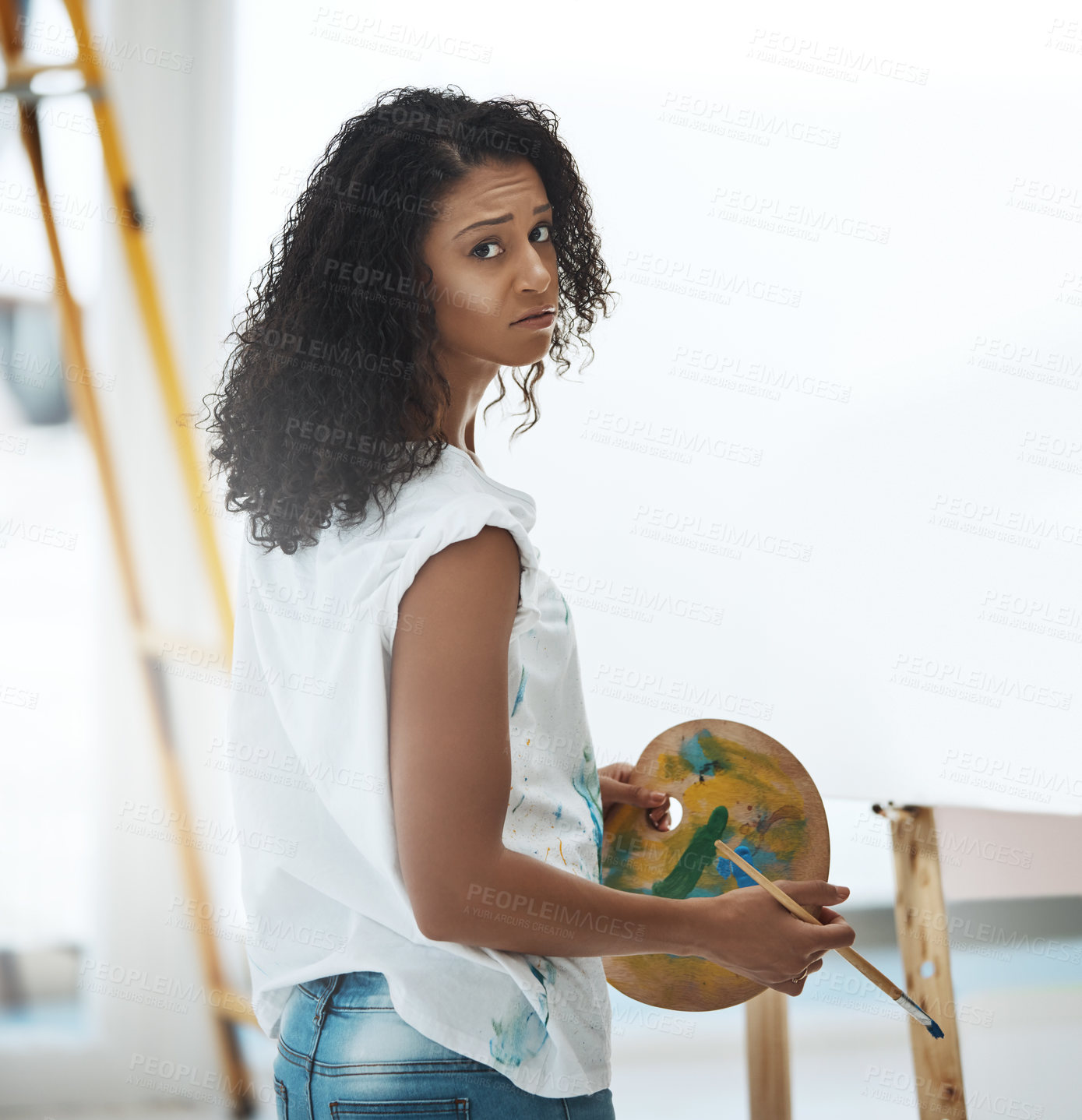 Buy stock photo Portrait of a young woman looking frustrated while trying to paint on a canvas at home