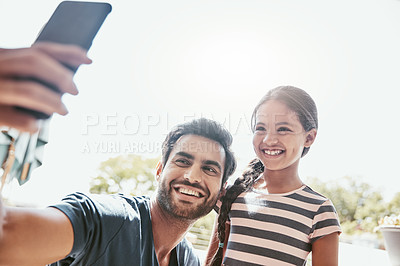 Buy stock photo Shot of a father and his daughter taking selfies together on a mobile phone