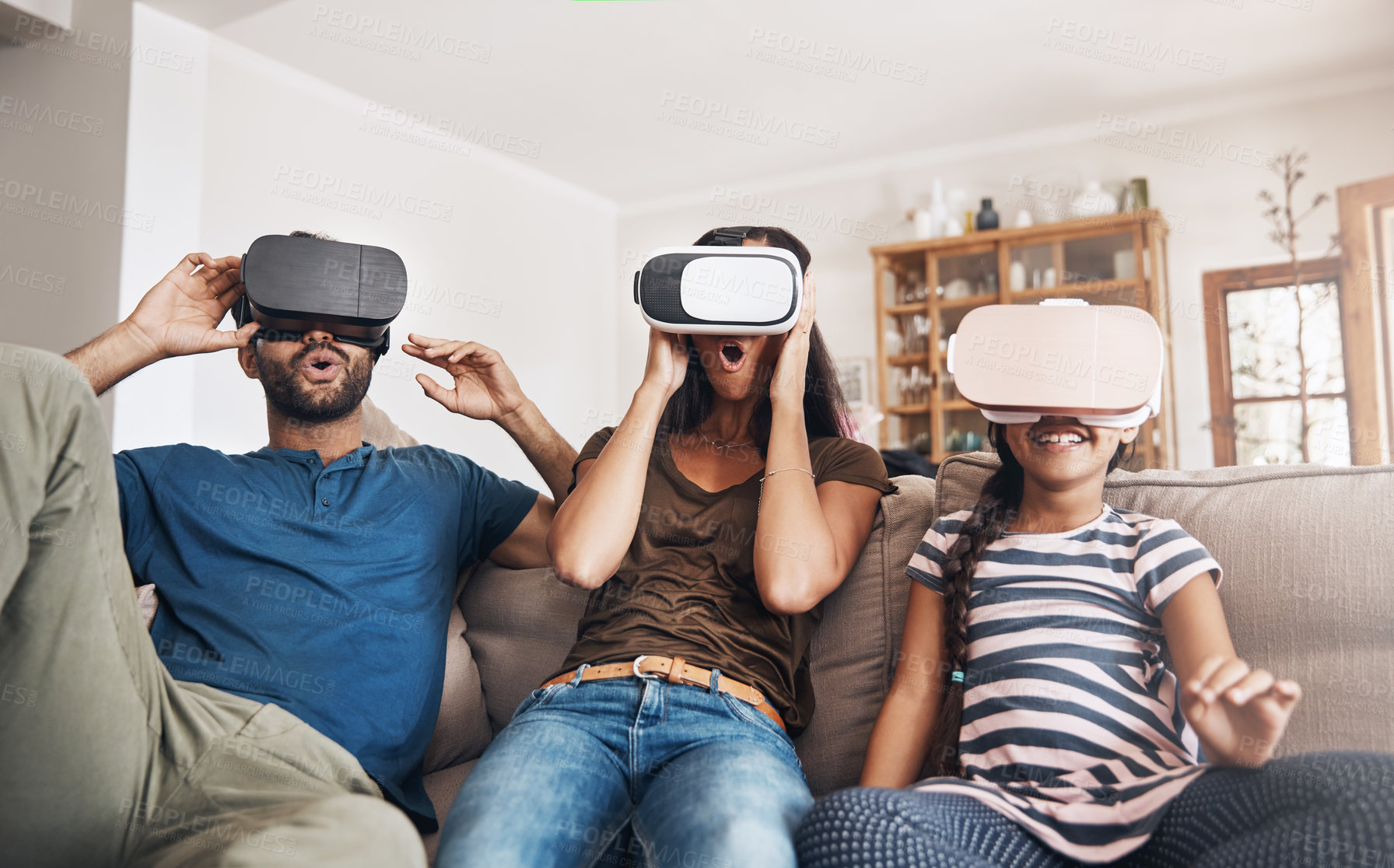 Buy stock photo Shot of a young family using virtual reality headsets together at home