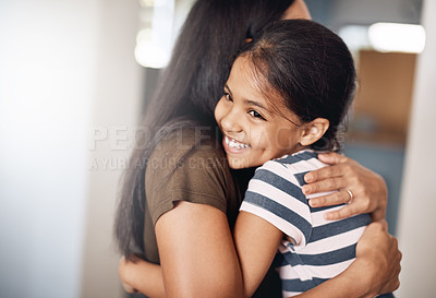 Buy stock photo Shot of a happy mother and daughter in a warm embrace at home