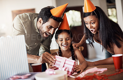 Buy stock photo Shot of a happy mother and father celebrating their daughter’s birthday at home