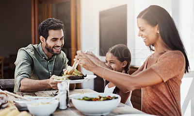 Buy stock photo Shot of a happy young family enjoying a meal together outdoors