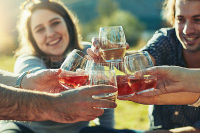 Buy stock photo Shot of a group of friends toasting with their drinks outdoors