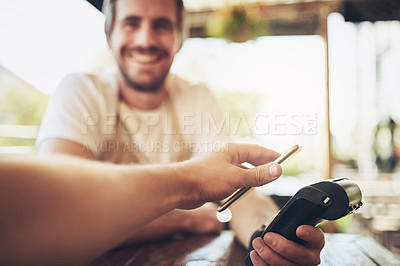 Buy stock photo Cropped shot of a man making wireless payment in a coffee shop