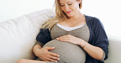 Buy stock photo Shot of a pregnant woman holding her belly at home