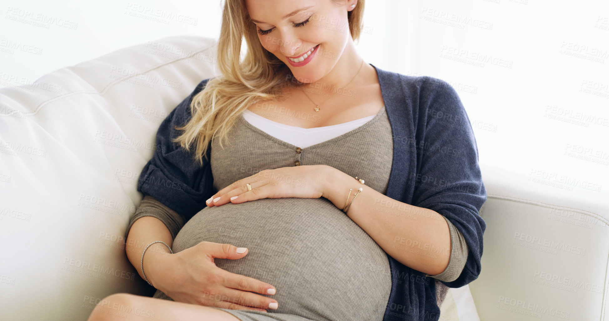 Buy stock photo Shot of a pregnant woman holding her belly at home