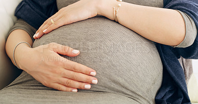 Buy stock photo Shot of an unrecognizable pregnant woman holding her belly at home