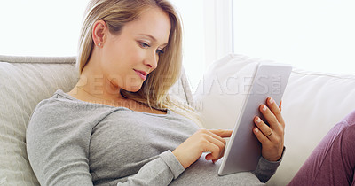 Buy stock photo Shot of a pregnant woman using a tablet at home
