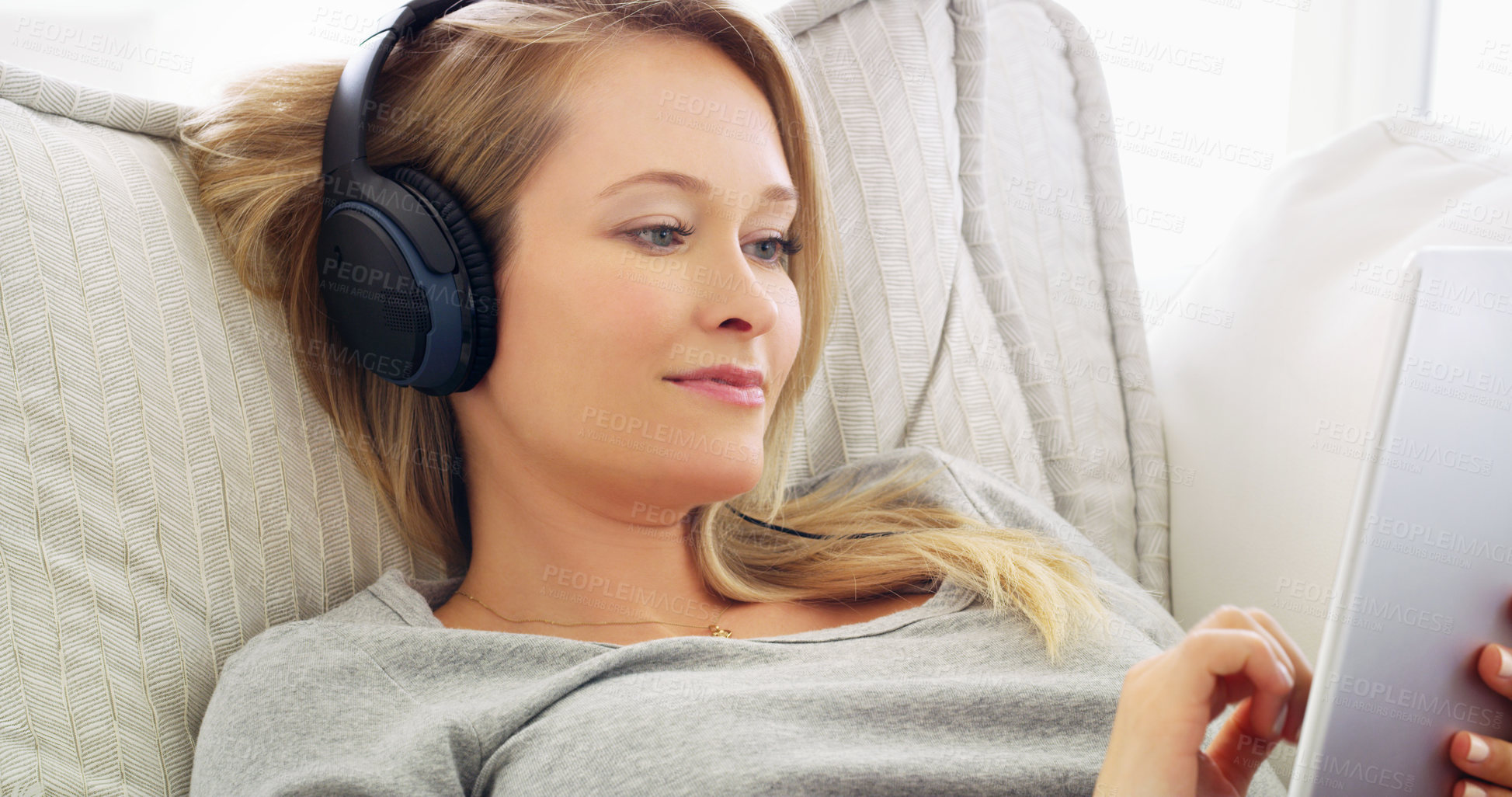 Buy stock photo Shot of an attractive young woman listening to music with headphones at home